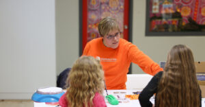 Photo of Summit DD team member Jessica showing small children assistive technology options.