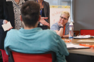 Two people sitting at a table and talking with each other.