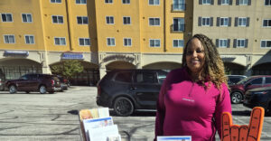 A Summit DD team members poses with an informational table while staffing a community outreach event.