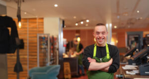 Smiling portrait of a young man with Down syndrome working at Panera.
