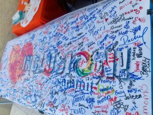 Summit DD's "I love inclusion" banner is spread on a table with hundreds of signatures written on it to showcase support for including people of all abilities.