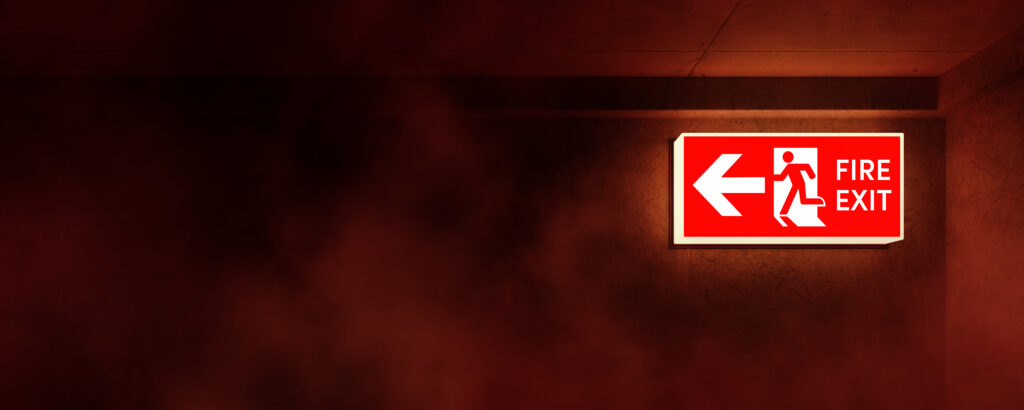 Illuminated emergency exit sign in hallway or office with smoke rising. Corridor point way out.