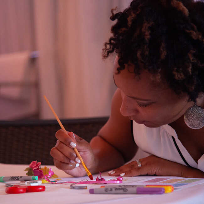 Principal Reese uses watercolor to create her wish banner at the Principal's Fellowship dinner