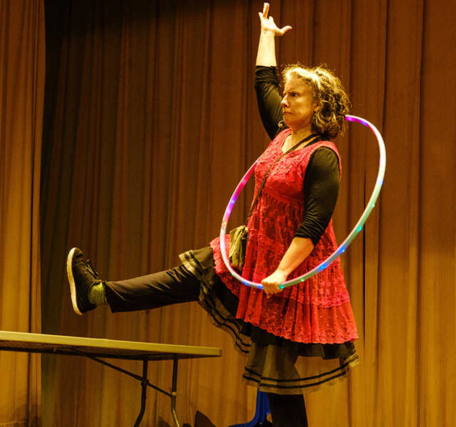 Michele Minnick poses with a hula hoop onstage.