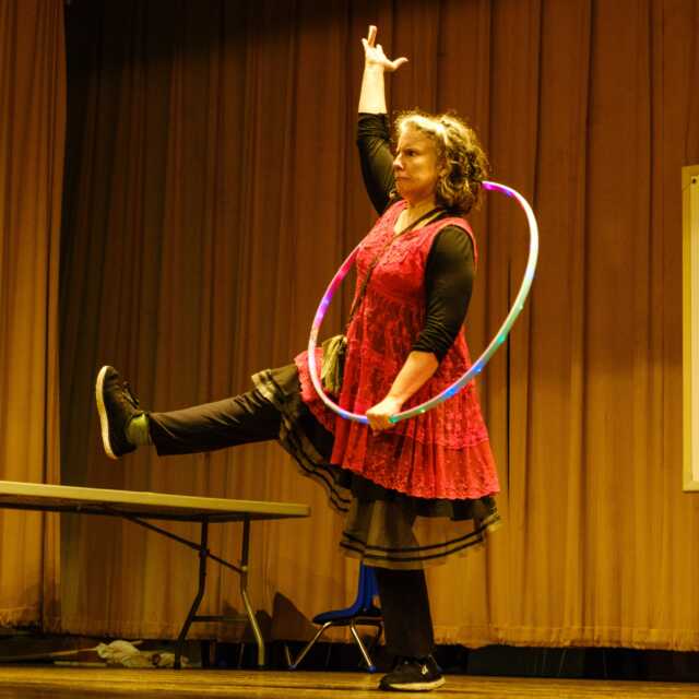 Michele Minnick poses with a hula hoop onstage.