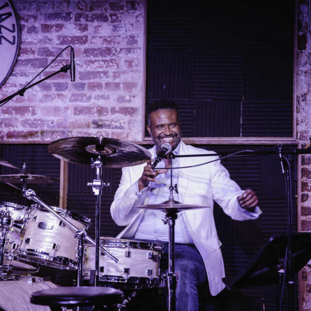 Vinton Jones smiles behind a drum set.