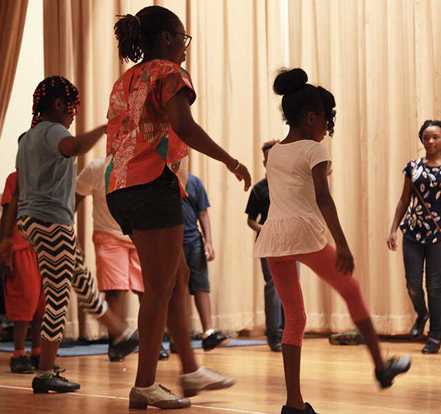 Quynn Johnson shows students how to use their feet to tap.
