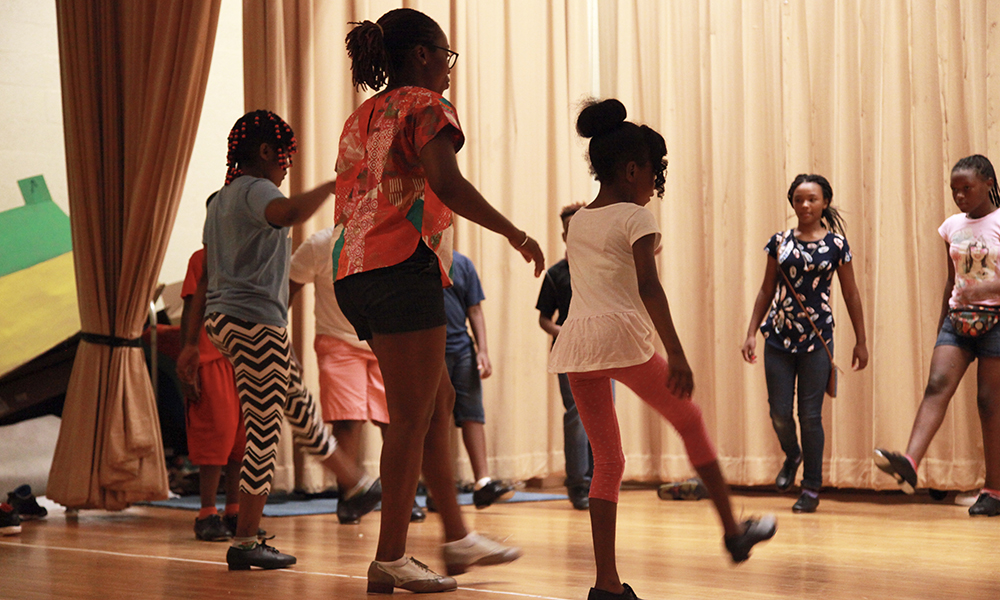 Quynn Johnson shows students how to use their feet to tap.