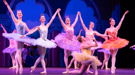A group of ballet dancers in costume take a bow