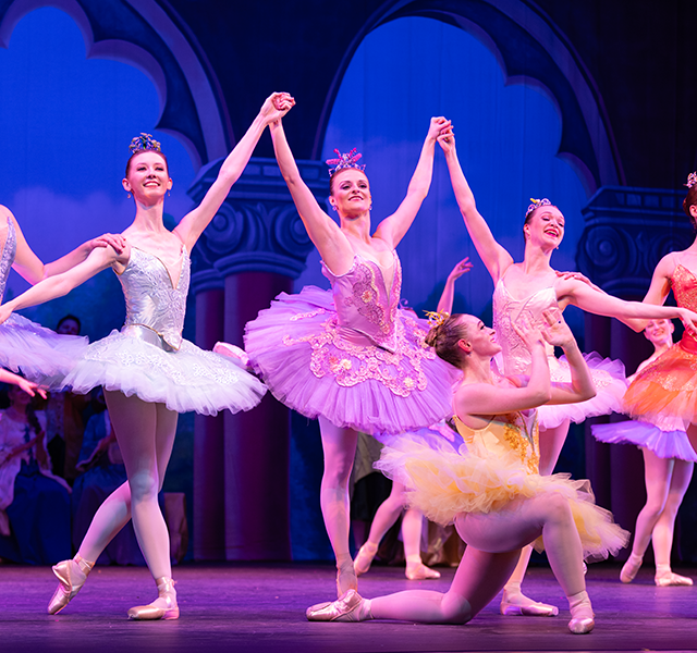 A group of ballet dancers in costume take a bow