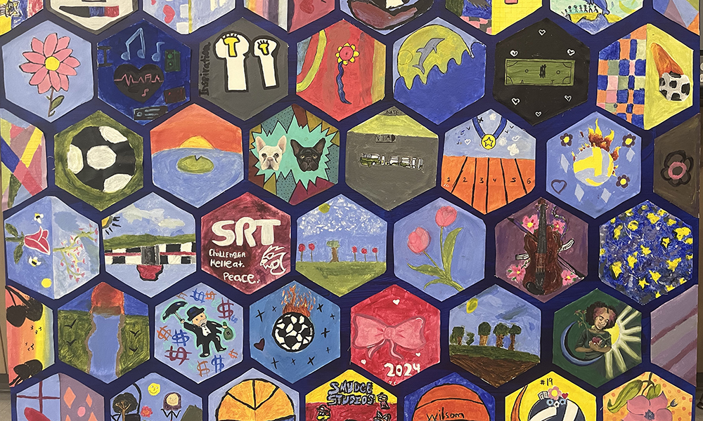 Multiple hand-painted hexagons by children are arranged on a blue background.