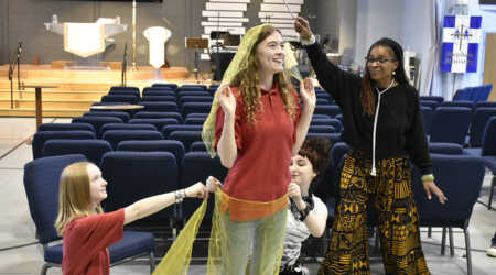 Tracie Jiggetts and students hold scarves and post mid-workshop.