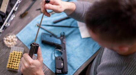 man cleaning gun using Zerust gun oil to prevent rust