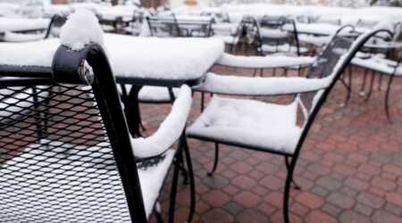Steel patio furniture with snow on it