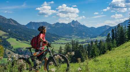 Woman on electric mountain bike on trail with mountain in the background