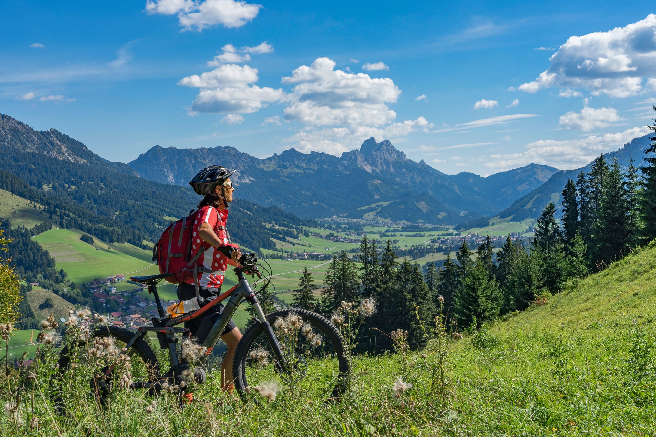 Woman on electric mountain bike on trail with mountain in the background