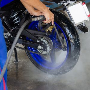 motorcycle wheel being cleaned with pressure sprayer