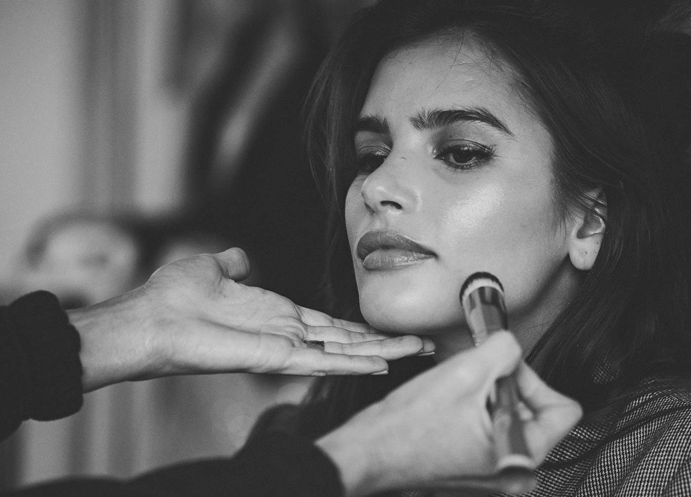 Cara applying Seint makeup on a model