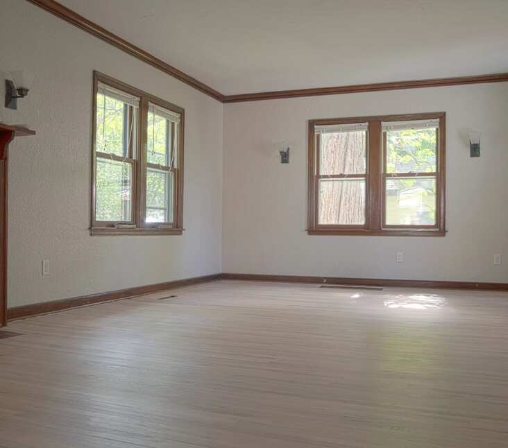 Red Oak Wood Finish in Empty Living Space. Fireplace set on the left.