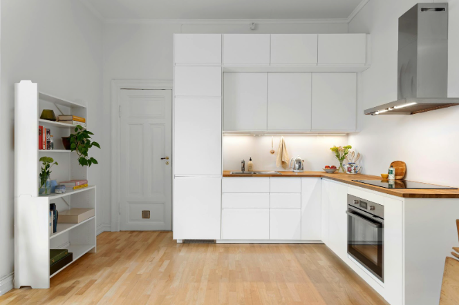A harmonious kitchen with white cabinets and hardwood floors.