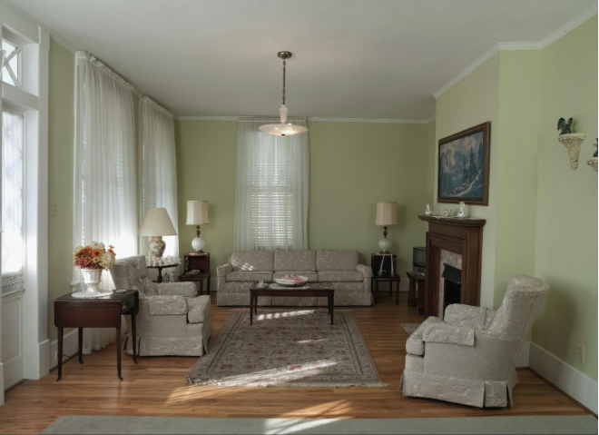 Living room with light hardwood floors and white cabinets.