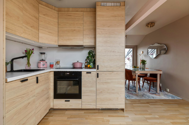 Modern kitchen with trendy hardwood flooring and white cabinets.