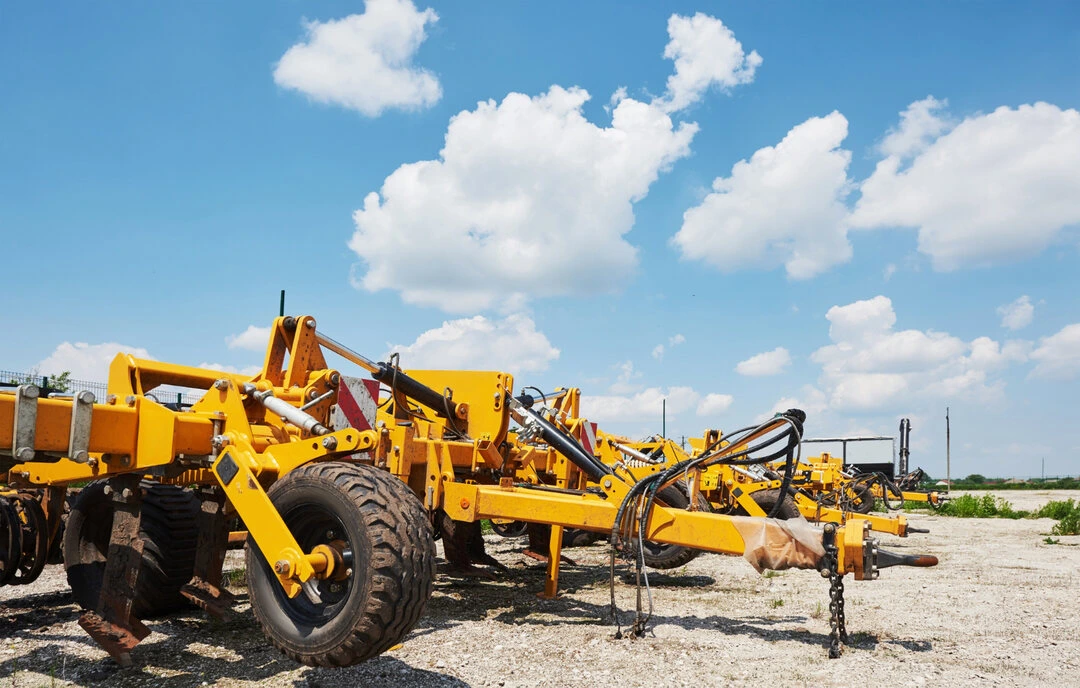 Large construction and agricultural equipment parked on a lot, ready for rental.