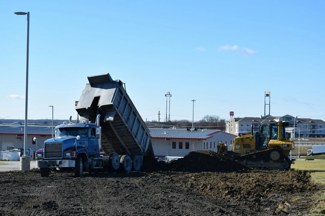 Heavy equipment rental dump truck at a construction site carrying materials