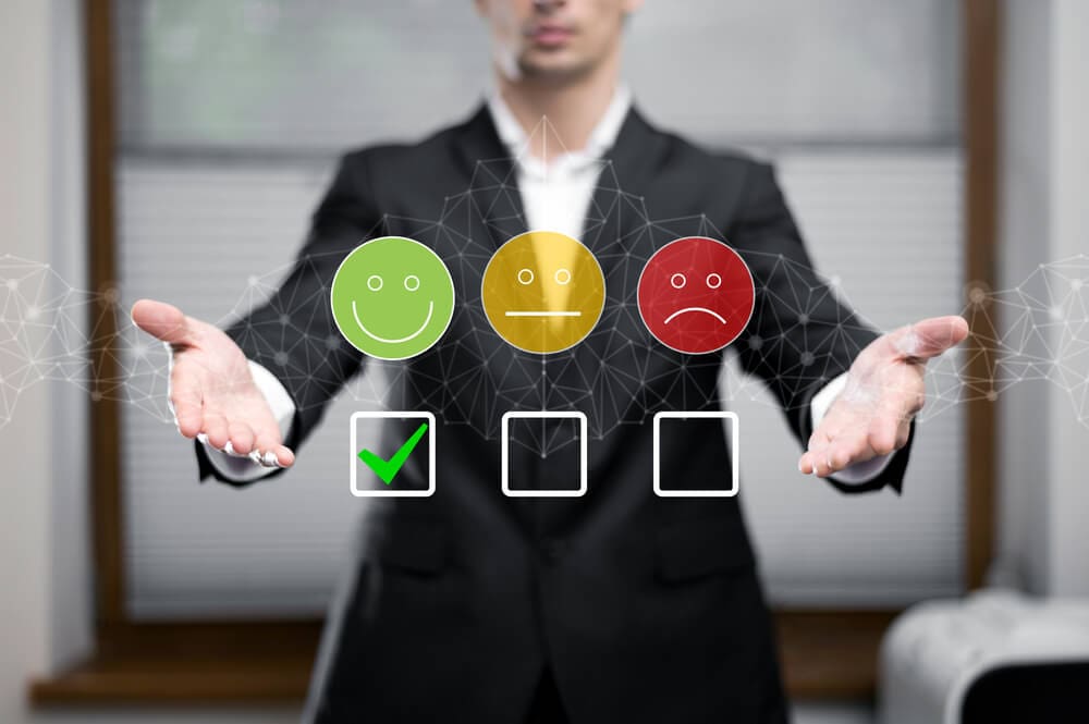 Person in suit presenting emoticons representing customer satisfaction levels in 2025