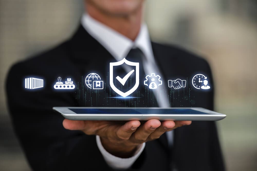 Professional with a tablet showing icons representing secure business operations in 2025