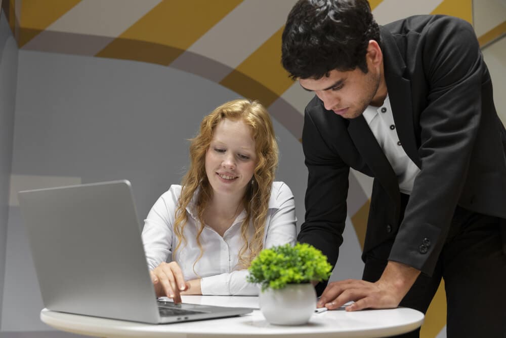 Two professionals collaborating over a laptop for smarter decision-making