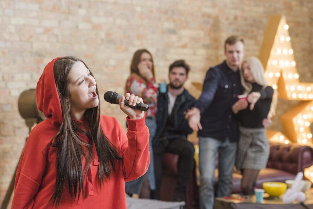 Friends singing and enjoying interactive party rentals with a karaoke machine.