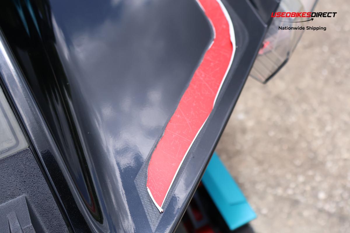 decals peeling off, cracks on bumper, damage to front bumper, road rash on side marker