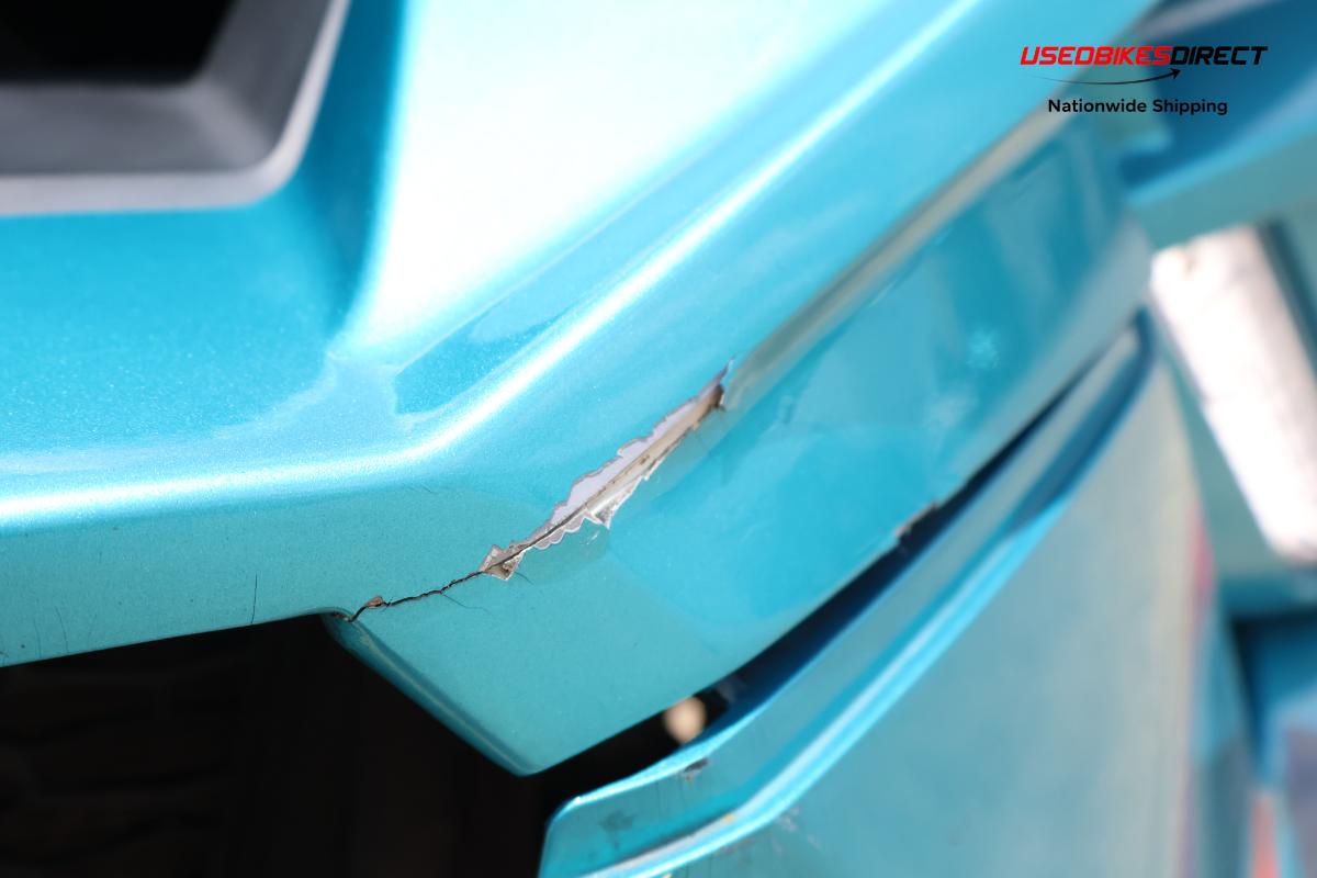 decals peeling off, cracks on bumper, damage to front bumper, road rash on side marker