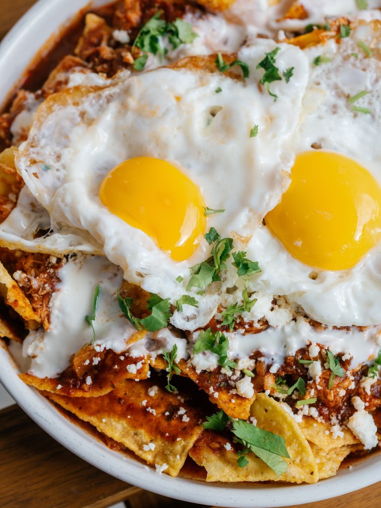 A plate of chilaquiles topped with sunny-side-up eggs, salsa, and cotija cheese in Williamson County, Tennessee.