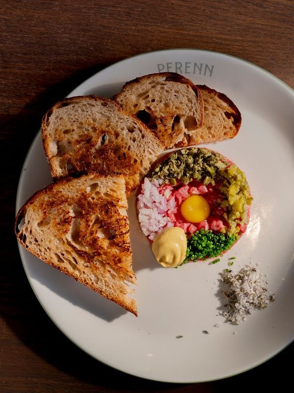 A plate with toast, steak tartare, egg yolk, mustard, and herbs in Williamson County, Tennessee.