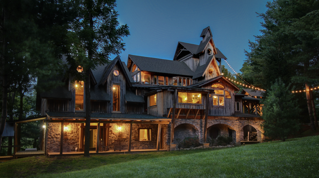 9 Unexpected Things To Do in Franklin A rustic wooden house with multiple gables and stone foundation nestled in a forest at dusk in Williamson County, Tennessee.
