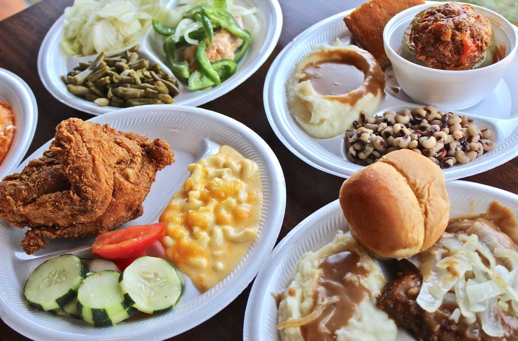 Several white plates filled with various Southern-style comfort foods on a wooden table in Williamson County, Tennessee.