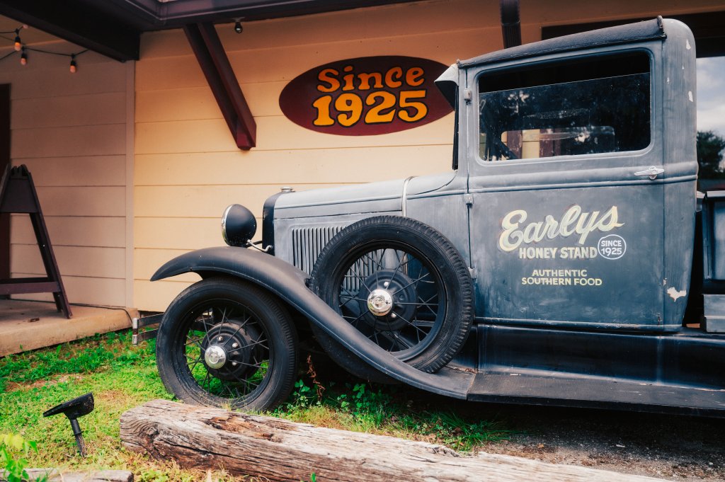 A vintage grey truck parked in front of a building labeled Earlys Honey Stand in Williamson County, Tennessee.