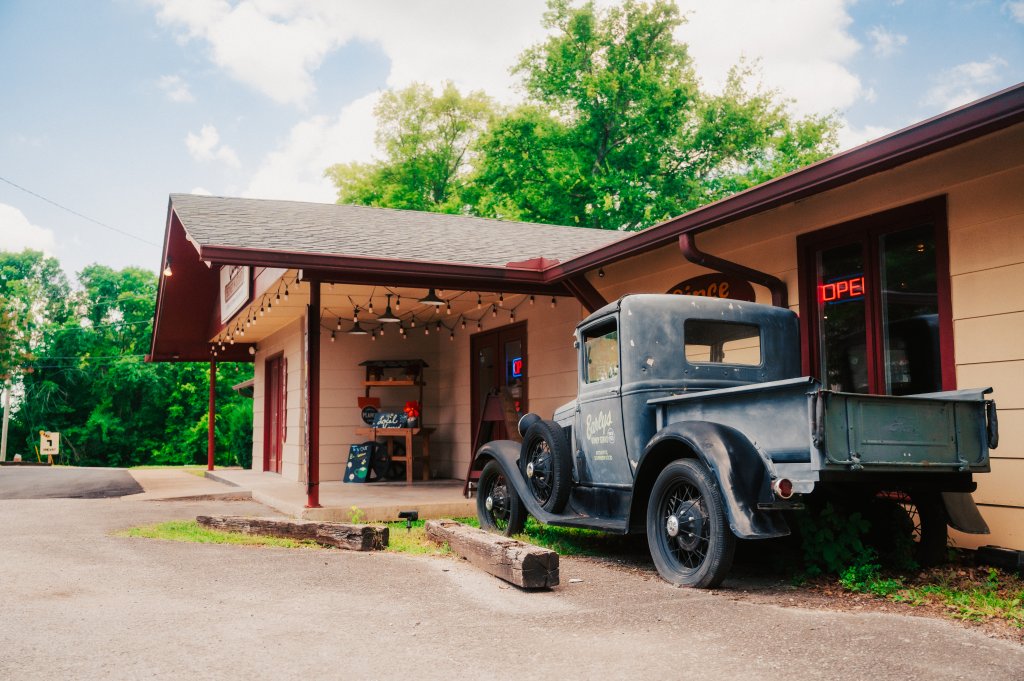A vintage black pickup truck parked in front of a small rural shop in Williamson County, Tennessee.