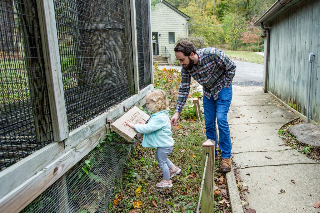 A father and young daughter looking at a sign outside an animal enclosure in Williamson County, Tennessee.