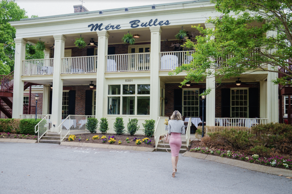 woman standing in front of restaurant in colonial-style mansions