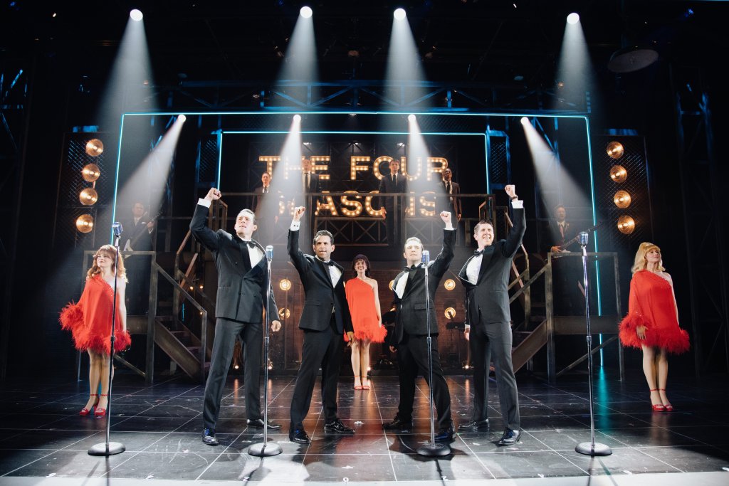 A group of five performers in formal attire celebrate on stage with raised arms in Williamson County, Tennessee.
