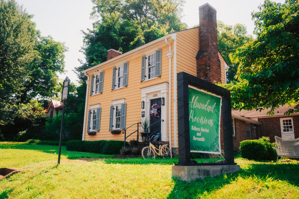 Your Guide to Discovering the Best of Spring Hill, Tennessee A yellow two-story house with a sign for Abundant Provisions Wellness Market and Mercantile in Williamson County, Tennessee.
