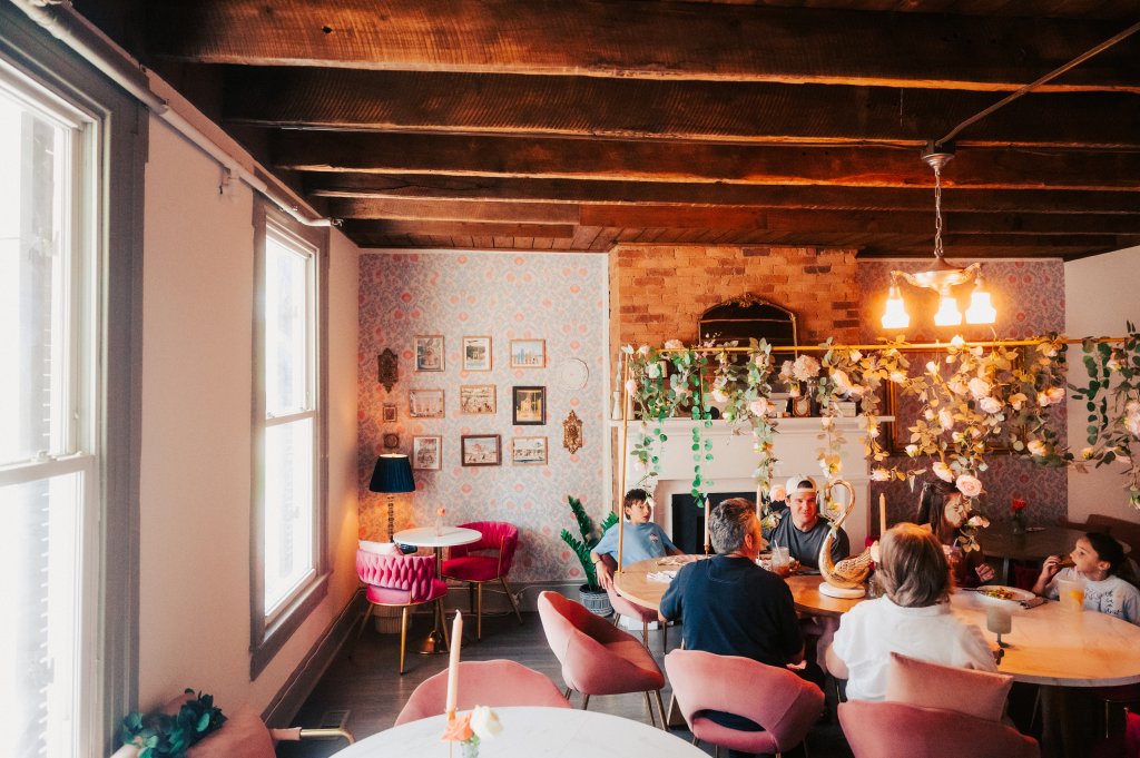 Your Guide to Discovering the Best of Spring Hill, Tennessee A group of people dining in a cozy, floral-decorated restaurant with pink velvet chairs in Williamson County, Tennessee.