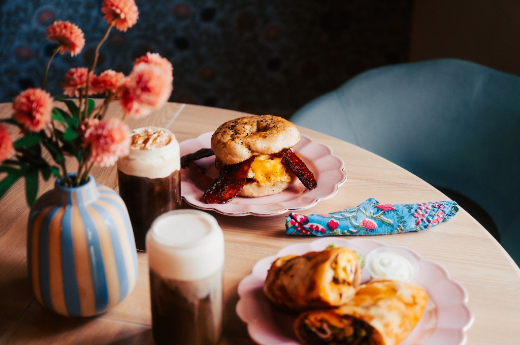 Your Guide to Discovering the Best of Spring Hill, Tennessee A breakfast spread featuring a bagel sandwich, wraps, and iced coffee on a table in Williamson County, Tennessee.