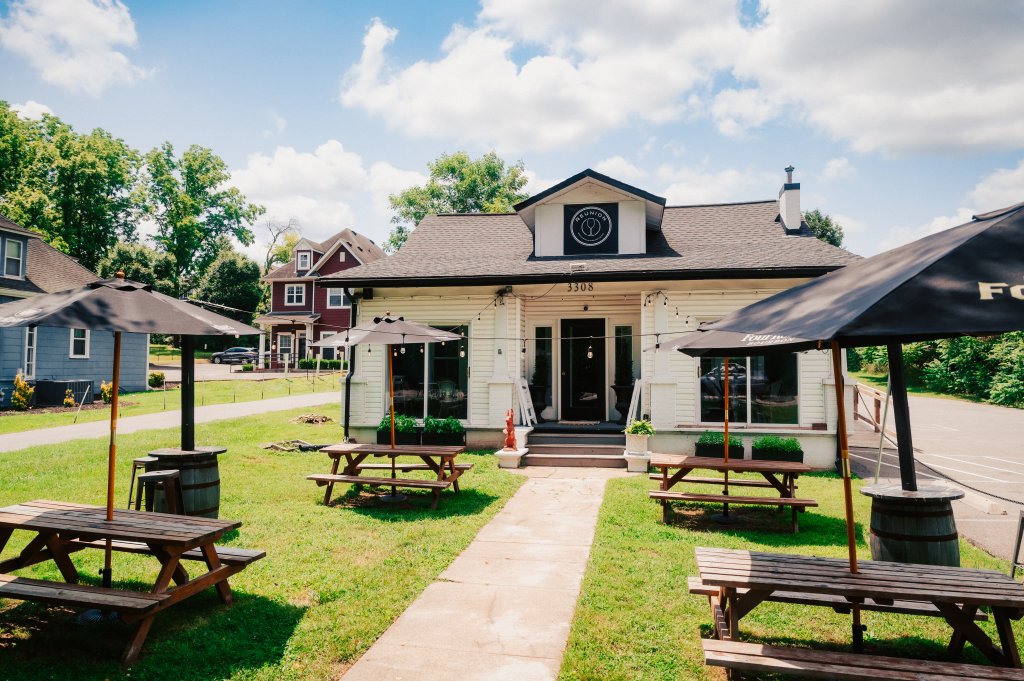 Your Guide to Discovering the Best of Spring Hill, Tennessee A white restaurant building with outdoor picnic tables and umbrellas on a sunny day in Williamson County, Tennessee.
