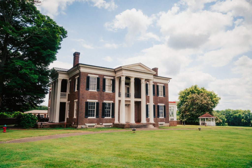 Your Guide to Discovering the Best of Spring Hill, Tennessee A grand brick mansion with white columns stands on a grassy lawn in Williamson County, Tennessee.