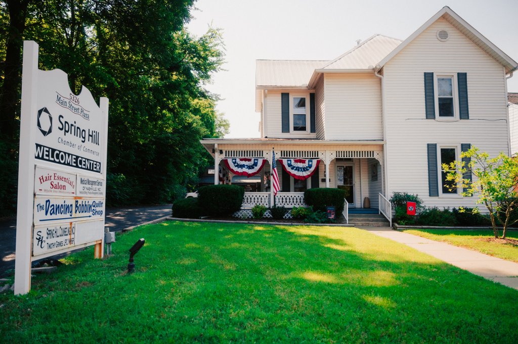 Your Guide to Discovering the Best of Spring Hill, Tennessee A white house with a porch decorated with patriotic bunting and a sign for businesses in Williamson County, Tennessee.