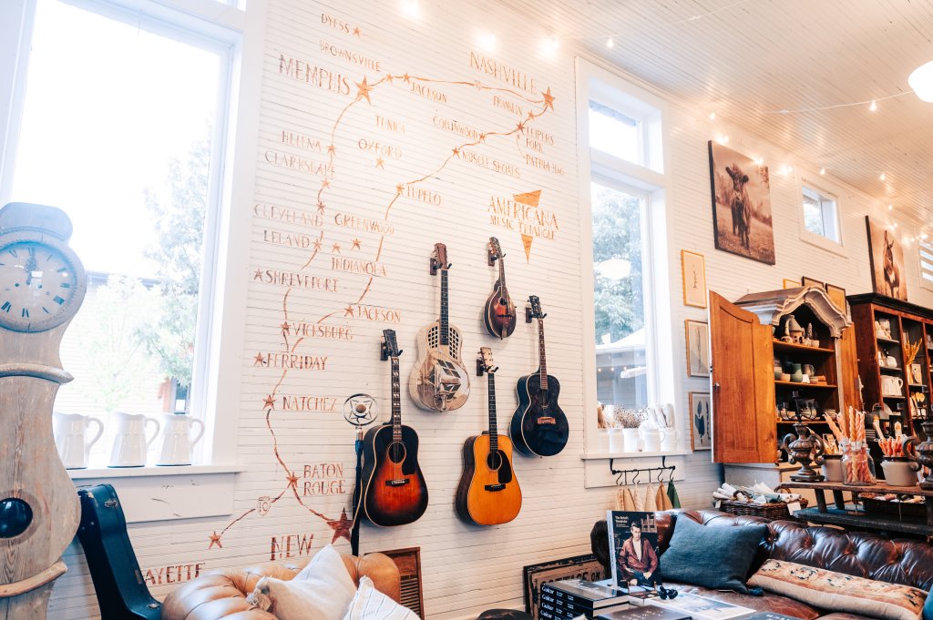 A cozy room with guitars on the wall, a clock, and a leather couch in Williamson County, Tennessee.